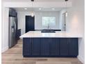 Modern kitchen with stainless steel appliances, island, and stylish pendant lighting at 1455 S Tennyson St, Denver, CO 80219