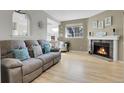 Bright living room with fireplace, light hardwood floors, and comfortable seating, ideal for relaxing or entertaining at 8312 S Saulsbury St # C, Littleton, CO 80128