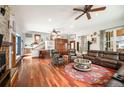 Spacious living room with a beautiful stone fireplace, hardwood floors, and comfortable leather furniture at 1205 Lee St, Lakewood, CO 80215