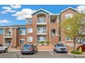 Exterior shot of a multi-story brick apartment building with private balconies and well-maintained landscaping at 2662 S Cathay Way # 302, Aurora, CO 80013