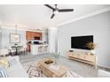 Cozy living room featuring carpet, a ceiling fan, contemporary furnishings, and seamlessly connected dining and kitchen areas at 2662 S Cathay Way # 302, Aurora, CO 80013