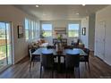 Bright dining area with a large table, seating for six, and sliding doors for indoor-outdoor living at 6077 Idlewild Pl, Brighton, CO 80601