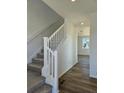 Carpeted staircase with white banister leads to the upper level of the home at 6077 Idlewild Pl, Brighton, CO 80601