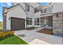 Inviting front entrance with covered porch and modern glass door, complemented by lush landscaping and a well-maintained lawn at 2230 Rim Ridge Dr, Castle Pines, CO 80108