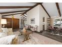 Inviting living room features vaulted ceilings with exposed beams and open floorplan at 3752 S Rosemary Way, Denver, CO 80237