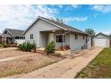Single-story home features a long driveway leading to a detached garage and a charming front porch at 436 S 4Th Ave, Brighton, CO 80601