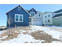 Blue and gray two-story house with a white garage door, and partial view of other homes at 39440 Congress Ln, Elizabeth, CO 80107