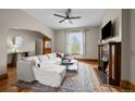 Inviting living room with hardwood floors, a fireplace, and a large window providing natural light and a ceiling fan at 14 S Lincoln St # 16, Denver, CO 80209
