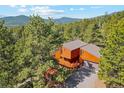 Aerial view of a rustic home nestled among lush evergreen trees in the mountains at 1278 Aspen Dr, Evergreen, CO 80439