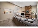 Comfortable living room featuring a stone fireplace and open layout at 1161 S Marshall St, Lakewood, CO 80232