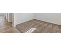 Corner view of a room with plush carpeting, white walls, and wood-look vinyl flooring at 14269 Beebalm Ave, Parker, CO 80134
