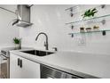 Modern kitchen featuring a stainless steel faucet, white countertops, and decorative wall accents at 1020 15Th St # 31E, Denver, CO 80202