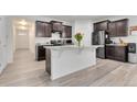 Stylish kitchen features dark cabinets, white countertops, an island and stainless steel appliances at 646 Gamble Oak St, Brighton, CO 80601