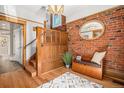 Welcoming entryway featuring brick wall, wooden banister staircase, and hardwood flooring at 1419 N Adams St, Denver, CO 80206