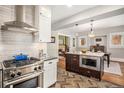 Open kitchen with stainless steel range, island, and seamless flow to dining area at 1419 N Adams St, Denver, CO 80206