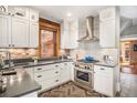 Well-equipped kitchen with stainless steel appliances, white cabinets, and exposed brick accents providing a homey feel at 1419 N Adams St, Denver, CO 80206