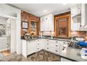 Charming kitchen with brick walls, white cabinets, and herringbone flooring creates a unique cooking space at 1419 N Adams St, Denver, CO 80206