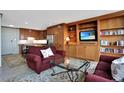 Cozy living space with custom wood built-ins, comfortable seating, and an open layout connecting to the kitchen at 3100 E Cherry Creek South Dr # 1507, Denver, CO 80209