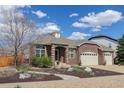 Charming brick home with a three-car garage, arched entryway, and tastefully landscaped front yard at 24621 E Berry Pl, Aurora, CO 80016