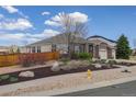 Brick home with three-car garage, arched entryway, landscaped yard, and a wooden privacy fence at 24621 E Berry Pl, Aurora, CO 80016