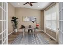 Home office featuring hardwood floors, neutral walls, a ceiling fan, and a large window with natural light at 24621 E Berry Pl, Aurora, CO 80016