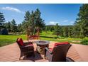 Backyard deck featuring outdoor furniture and fire pit, perfect for enjoying serene outdoor living at 29263 Sue Rd, Evergreen, CO 80439