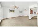 Bright and airy living room with neutral carpeting and ceiling fan at 11040 Emerson St, Northglenn, CO 80233