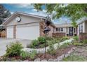 Charming brick home featuring a beautifully landscaped front yard with mature trees and a welcoming entrance at 13959 W Cedar Pl, Golden, CO 80401