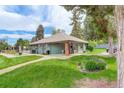 View of the side of the pool house showing a well-kept lawn and landscaping at 3518 S Depew St # 102, Lakewood, CO 80235
