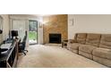 A cozy living room with a stone fireplace and a sliding glass door that leads to the outside at 3518 S Depew St # 102, Lakewood, CO 80235