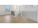 View of the staircase with wood flooring, black metal railings, and a pendant light fixture at 42972 Colonial Trl, Elizabeth, CO 80107