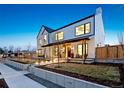 Stunning two-story home with a covered porch and warm exterior lighting at 4520 W Moncrieff Pl, Denver, CO 80212