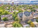 Stunning aerial view of a residential area, with lush greenery, and cityscape in the distance at 1140 Columbine St # 106, Denver, CO 80206