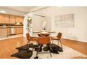 Well lit dining area with wood floors, a round table with seating for four, and a partial kitchen view at 1140 Columbine St # 106, Denver, CO 80206