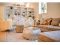 Stylish living room featuring custom shelving, natural light, and comfortable seating arrangement at 1140 Columbine St # 106, Denver, CO 80206