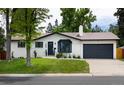 Charming one-story home with a well-maintained lawn and black garage door at 3400 S Ivy Way, Denver, CO 80222
