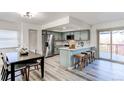 Stylish kitchen featuring stainless steel appliances, a breakfast bar with seating, and a view to the deck at 18874 E Mexico Dr, Aurora, CO 80017