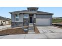 New construction two-story home featuring stone accents, a covered porch, and an attached two-car garage at 1871 Grayside Cir, Castle Rock, CO 80109