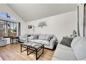 Bright living room features a vaulted ceiling, light gray sofas, and modern decor at 4146 S Mobile Cir # A, Aurora, CO 80013