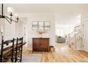 Bright and open entryway with hardwood floors, decorative furniture, and a view into the living room and staircase at 7382 E 8Th Pl, Denver, CO 80230