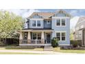 Charming two-story home featuring blue siding, white trim, a welcoming front porch, and well-manicured landscaping at 7382 E 8Th Pl, Denver, CO 80230