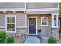 Cozy covered porch featuring a wreath on the front door and decorative flower pots at 9066 Apache Plume Dr # E, Parker, CO 80134
