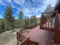 Wooden deck offering scenic views of surrounding trees and a picnic area, perfect for outdoor enjoyment and entertaining at 11608 Apache Trl, Conifer, CO 80433