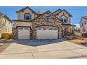Beautiful two-story home featuring stone accents, three-car garage, and well-kept front yard at 2702 Rising Moon Way, Castle Rock, CO 80109