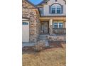 Charming front porch with stone pillars, and an ornate front door at 2702 Rising Moon Way, Castle Rock, CO 80109