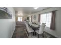 Bright dining room with a modern table and white chairs, flowing into a comfortable living area at 5559 Gibraltar St, Denver, CO 80249