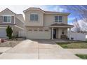Charming two-story home boasts a tile roof, a covered porch, and a two-car attached garage at 5559 Gibraltar St, Denver, CO 80249