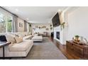 Bright living room featuring a fireplace, a large sectional sofa, and hardwood floors at 2359 Dogwood Dr, Erie, CO 80516