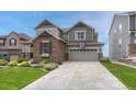 Charming two-story home featuring stone accents, a two-car garage, a basketball hoop and landscaped front yard at 12059 S Tallkid Ct, Parker, CO 80138