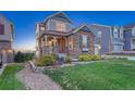 Beautiful two-story home featuring stone accents and professional landscaping at dusk at 12059 S Tallkid Ct, Parker, CO 80138
